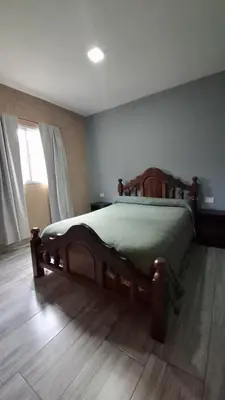 a bedroom with a wooden bed in a room at Entre Sierras Cabañas in Tanti