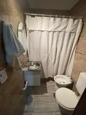 a bathroom with a toilet and a sink and a shower at Entre Sierras Cabañas in Tanti
