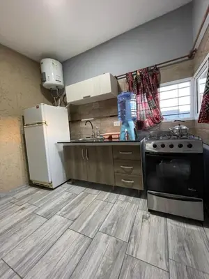 a kitchen with a white refrigerator and a stove at Entre Sierras Cabañas in Tanti