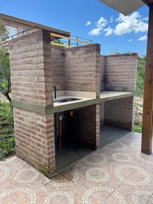 an outdoor kitchen with a brick wall at Balcones del Cristal - Picaflor in Tanti