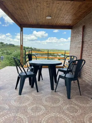 a table and chairs on a patio with a view at Balcones del Cristal - Picaflor in Tanti