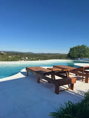 two wooden picnic tables next to a swimming pool at Balcones del Cristal - Picaflor in Tanti
