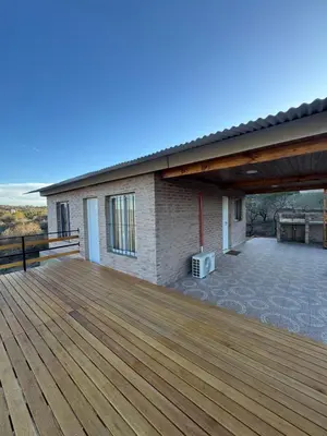 a large wooden deck with a building at Balcones del Cristal - Picaflor in Tanti