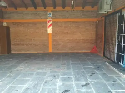 an empty garage with a brick wall and a red and white pole at Cabañas Ojo de Agua in Trapiche