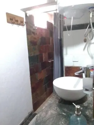 a bathroom with a white sink and a brick wall at Cabañas Ojo de Agua in Trapiche