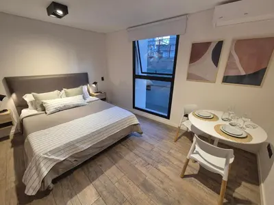a bedroom with a bed and a table with chairs at Oasis Urbano - bello departamento amoblado en la mejor zona de Guemes in Cordoba
