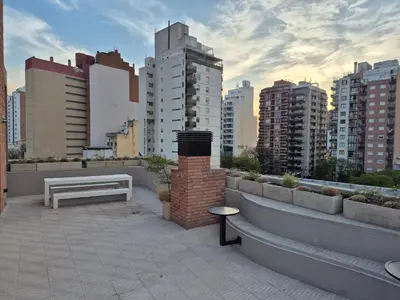 a bench on a rooftop with a city skyline at Oasis Urbano - bello departamento amoblado en la mejor zona de Guemes in Cordoba
