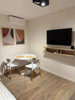 a living room with a table and a tv at Oasis Urbano - bello departamento amoblado en la mejor zona de Guemes in Cordoba