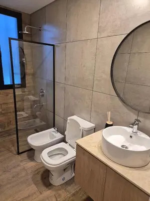 a bathroom with a toilet and a sink and a mirror at Oasis Urbano - bello departamento amoblado en la mejor zona de Guemes in Cordoba