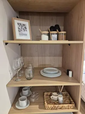 a wooden shelf with plates and dishes on it at Oasis Urbano - bello departamento amoblado en la mejor zona de Guemes in Cordoba