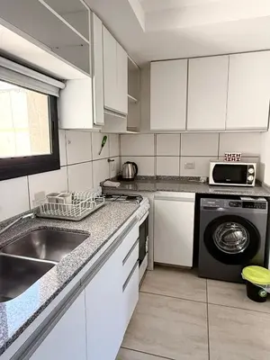 a kitchen with a sink and a washing machine at Departamento con piscina General Paz in Cordoba