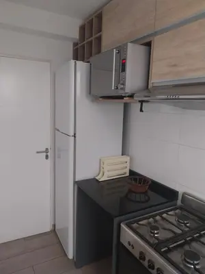 a kitchen with a stove and a white refrigerator at Las Pircas PB in Alta Gracia