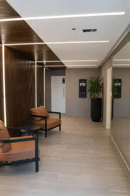 a hallway in a hospital with chairs and a plant at Las Pircas PB in Alta Gracia