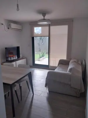 a living room with a bed and a table at Las Pircas PB in Alta Gracia