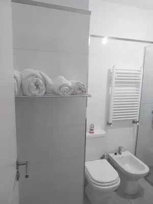 a white bathroom with a toilet and a sink at Las Pircas PB in Alta Gracia