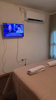 a bedroom with a bed with a tv on the wall at CBA Apart in Cordoba