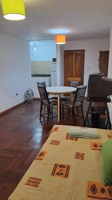 a living room with a table and chairs and a piano at CBA Apart in Cordoba