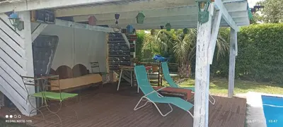 a covered deck with chairs and a table and a table at Nuevos Aires in Los Reartes