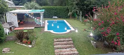 a small swimming pool in a yard with flowers at Nuevos Aires in Los Reartes