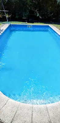 a swimming pool with blue water in a yard at Nuevos Aires in Los Reartes