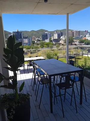 a table and chairs on a patio with a view of a city at ALOJATE PREMIUM VILLA CARL0S PAZ - STEFANO 1 dor in Villa Carlos Paz