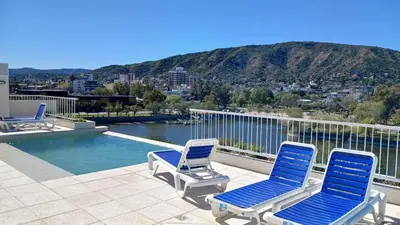 two blue chairs and a swimming pool on a balcony at ALOJATE PREMIUM VILLA CARL0S PAZ - STEFANO 1 dor in Villa Carlos Paz