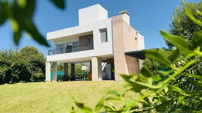 a house on a hill with green grass at Casa Potrero de Garay pileta in La Estancia