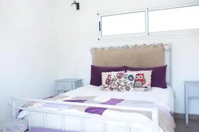 a bedroom with a white bed with pillows and a window at Casa Potrero de Garay pileta in La Estancia