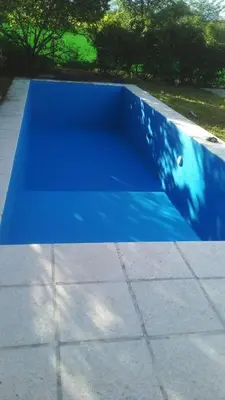 a blue cover on a concrete slab with trees in the background at Casa Potrero de Garay pileta in La Estancia