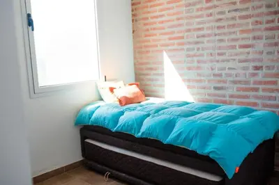 a bed in a room with a brick wall at Casa Potrero de Garay pileta in La Estancia