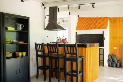 a kitchen with two bar stools and a counter at Casa Potrero de Garay pileta in La Estancia