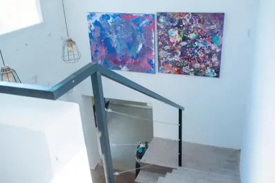 a dog standing under a glass staircase with two paintings at Casa Potrero de Garay pileta in La Estancia