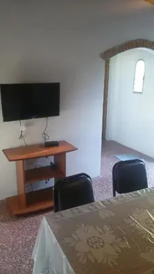a room with a tv and a table with two chairs at Sierras y sol in Villa Cura Brochero