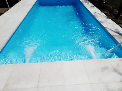 a swimming pool with blue water in it at Sierras y sol in Villa Cura Brochero