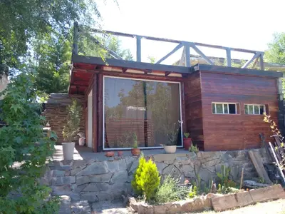 a house with a large window on a stone wall at La tranquera in Trapiche