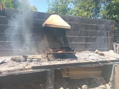 a brick oven with smoke coming out of it at La tranquera in Trapiche