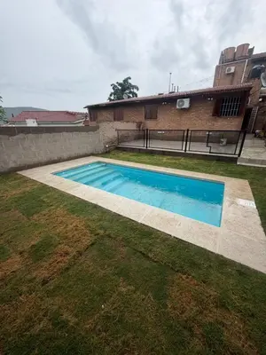 a swimming pool in a yard next to a building at Cabaña Becciu in Villa Carlos Paz