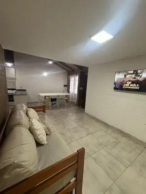 a living room with a couch and a table at Cabaña Becciu in Villa Carlos Paz