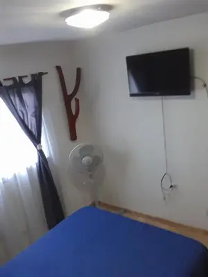 a bedroom with a tv on the wall next to a window at Cactus in Villa Carlos Paz