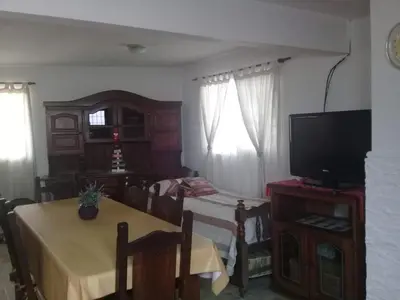 a living room with a dining table and a television at Cactus in Villa Carlos Paz