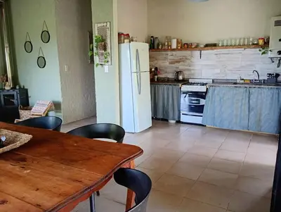 a kitchen with a table and a white refrigerator at El Chañar in Cordoba