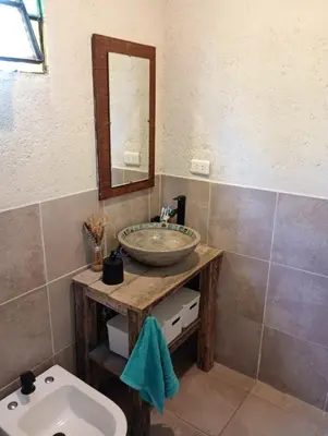 a bathroom with a sink and a mirror and a toilet at El Chañar in Cordoba