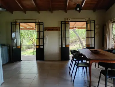 a dining room with a wooden table and chairs at El Chañar in Cordoba