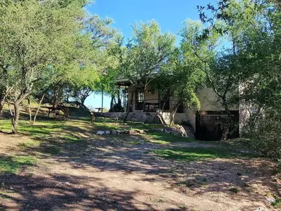 a house with trees in front of it at El Chañar in Cordoba
