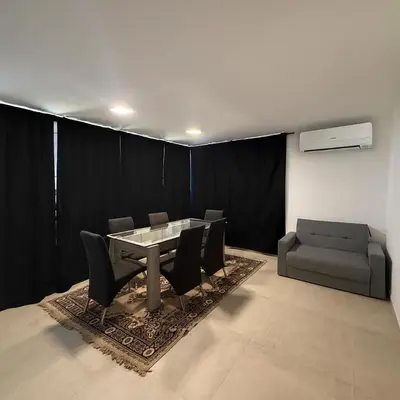 a dining room with a table and chairs and a couch at Departamentos Cañitas in Malagueño