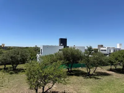 a park with trees and buildings in the background at Departamentos Cañitas in Malagueño