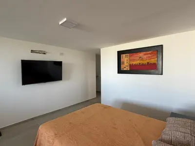 a bedroom with a bed and a flat screen tv at Monoambiente Cañitas in Malagueño