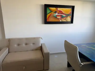 a living room with a couch and a painting on the wall at Monoambiente Cañitas in Malagueño