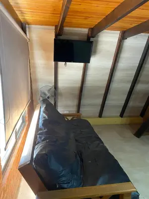 a small bed in a room with a wooden ceiling at Complejo alpinas del valle in Santa Rosa de Calamuchita