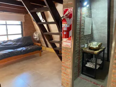 a room with a loft with a bed and stairs at Complejo alpinas del valle in Santa Rosa de Calamuchita